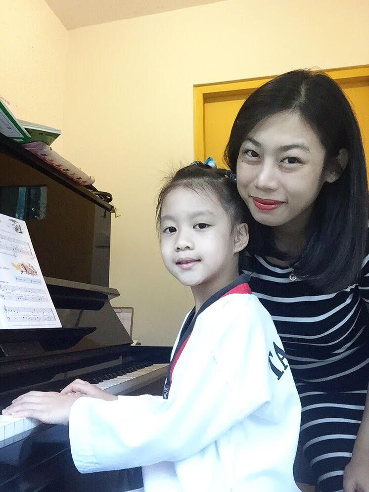 Minnie supporting a young piano student during a recital